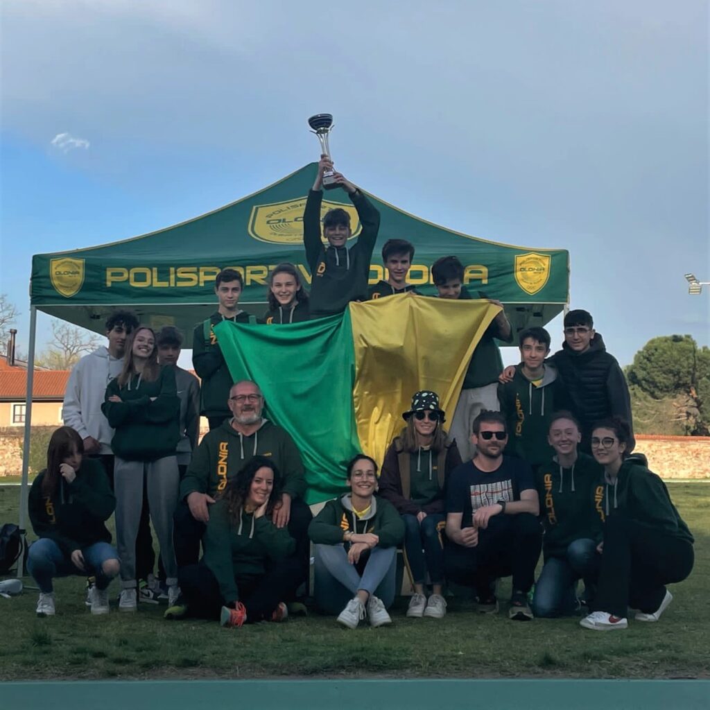 Alcuni atleti e tecnici della Polisportiva Olonia con coppa e bandiera giallo-verde alla conclusione della gara.